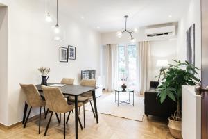 a dining room and living room with a table and chairs at Peaceful 2BD Apartment in Kolonaki by UPSTREET in Athens