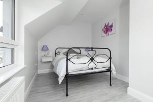 a white bedroom with a bed with a metal frame at Godfrey Mews in Newry