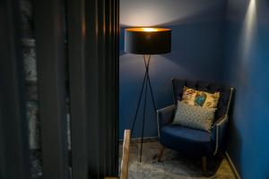 a blue room with a chair and a lamp at ZIGZAG HOSTEL in Praia da Vitória