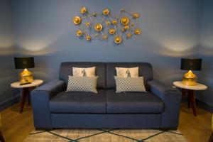 a blue couch in a living room with two tables at ZIGZAG HOSTEL in Praia da Vitória