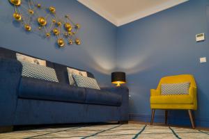 a blue room with a couch and a yellow chair at ZIGZAG HOSTEL in Praia da Vitória