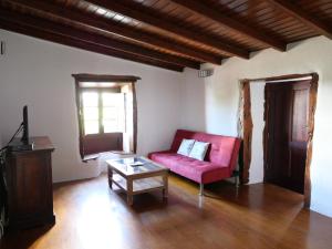 un soggiorno con un divano rosso e un tavolo di Casa Rural Los Llanillos a Frontera