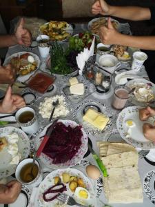 eine Gruppe von Menschen, die an einem Tisch mit Essen sitzen in der Unterkunft Rubina Bed and Breakfast in Tatev