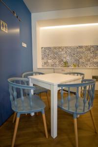 a white table with blue chairs in a room at ZIGZAG HOSTEL in Praia da Vitória