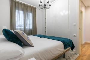 A bed or beds in a room at Gran Via 1.2 by Forever Rentals