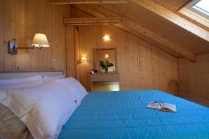 a bedroom with a bed with two books on it at Grand TheoNi Boutique Hotel & Spa in Vasiliki