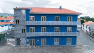 a blue building with a red roof at ZIGZAG HOSTEL in Praia da Vitória