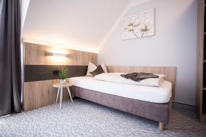 1 dormitorio con cama y mesa pequeña en Amtsstüble Hotel & Restaurant, en Mosbach