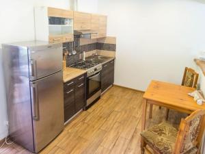 a kitchen with a stainless steel refrigerator and a table at Albertówka in Trzciel