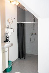 a bathroom with a shower with a black shower curtain at Ballum Slusekro in Ballum