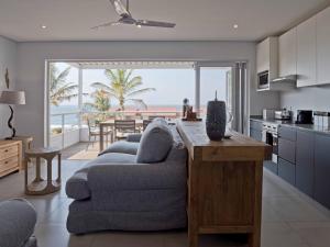 a kitchen and living room with a couch and a table at Umdloti Holiday Resort Apartments in Umdloti