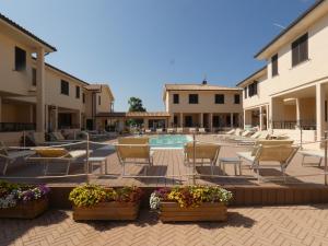 a patio with chairs and a pool in a courtyard at Residence Talamone Il Poderino in Talamone