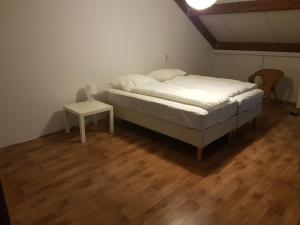 ein Schlafzimmer mit einem Bett und einem Tisch auf einem Holzboden in der Unterkunft Middensluis 7 in Wemeldinge