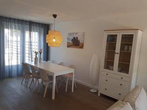 Middensluis 7 في فيملدينج: غرفة طعام مع طاولة بيضاء وكراسي