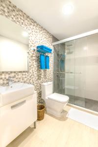 a bathroom with a toilet and a sink and a shower at Ithaa Dhigurah in Dhigurah