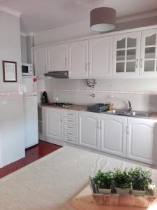 ナザレにあるApartamento Nazaréの白いキャビネットとシンク付きのキッチン