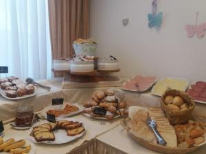 una mesa con diferentes tipos de pasteles. en Hotel Maita, en Lido di Camaiore