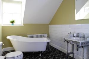 uma casa de banho com uma banheira, um lavatório e um WC. em Number 6 em Whitby