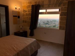 a bedroom with a bed and a window with a view at Villa Lyons in Żejtun