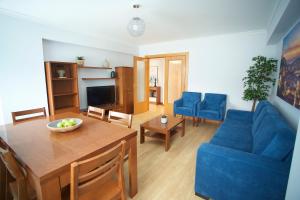- un salon avec une table et un canapé bleu dans l'établissement Meriteluna Mountain - Lisboa, Sintra e Cascais, à Agualva