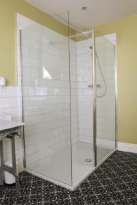 W łazience znajduje się prysznic ze szklanymi drzwiami. w obiekcie Number 6 w mieście Whitby