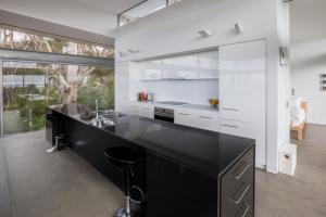a kitchen with a black counter and a sink at Avalon Coastal Retreat in Swansea