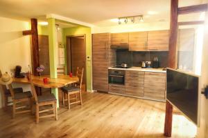 a kitchen with a wooden table and a wooden floor at L’Échappée Verte in Sainte-Croix-aux-Mines