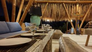 a restaurant with a table with wine glasses on it at Coco Verde Bali Resort in Tanah Lot