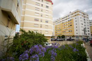 two tall buildings with purple flowers in front of them at Meriteluna Mountain - Lisboa, Sintra e Cascais in Agualva