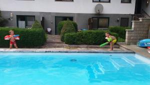 two young children playing with a toy in a swimming pool at Lamplhof B&B in Wiesing