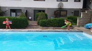 zwei kleine Kinder spielen mit einem Spielzeug im Pool in der Unterkunft Lamplhof B&B in Wiesing