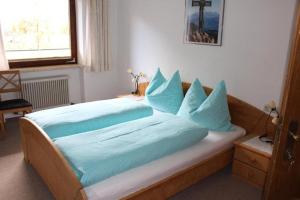 a bedroom with a large bed with blue pillows at Lamplhof B&B in Wiesing