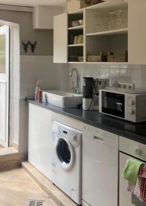 a kitchen with a washing machine and a sink at Apartementhaus 2 Kornstraße in Bremen