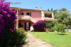 una casa con fiori viola davanti di Casa Smeralda a Cannigione