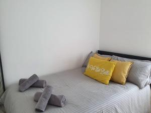 ein Bett mit zwei Kissen und Handtüchern darauf in der Unterkunft Broadway Belfast in Belfast