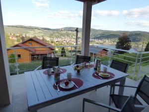 einen Tisch auf dem Balkon mit Bergblick in der Unterkunft les charmes du lac Sauna et Spa in Gérardmer