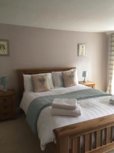 a bedroom with a large bed with towels on it at Springwells in Dunkeld