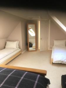 a attic bedroom with two beds and a mirror at Springwells in Dunkeld +3 photos