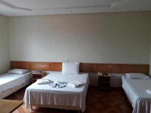 a hotel room with two beds with towels on them at Hotel Litoral in Aracaju