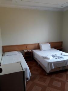 a room with two beds and a tv in it at Hotel Litoral in Aracaju