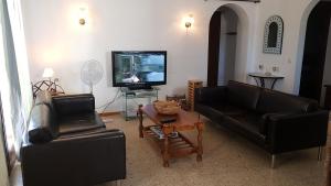 エンプリアブラバにある010 Segre Aptのリビングルーム(革張りのソファ2台、テレビ付)