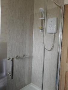 a shower with a glass door in a bathroom at 27 Garenin in Carloway