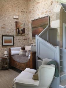 een woonkamer met een bank en een stoel bij Chez Brown in Saint-Thomas-de-Cônac