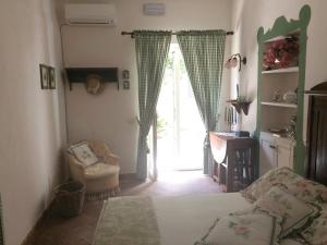 a bedroom with a bed and a window and a chair at B&B del Giglio in Cefalù