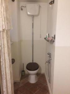 a bathroom with a toilet with a black seat at B&B del Giglio in Cefalù