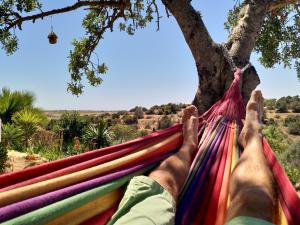 une personne allongée dans un hamac sous un arbre dans l'établissement Casa Pura Vida - fantastic sea view, à Pêra