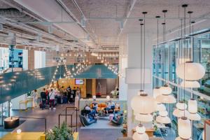 een weergave van een lobby met mensen in stoelen bij Hotel Casa Amsterdam in Amsterdam