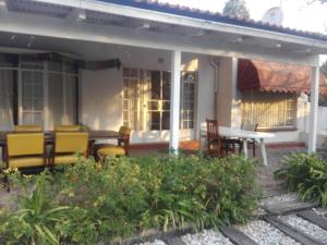 a house with chairs and a table on a patio at Fourways Guest Lodge in Johannesburg