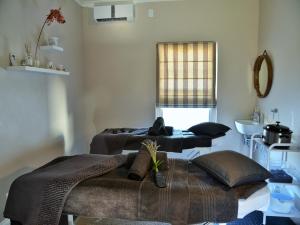 A bed or beds in a room at Mont d'Or Swartberg Hotel