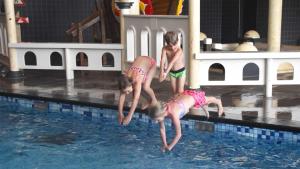 twee jonge kinderen die in een zwembad springen bij Molecaten Park Noordduinen in Katwijk